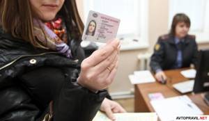 Водительское удостоверение в руках женщины, которая находится в участке ГИБДД